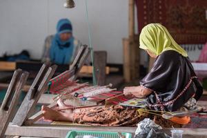 woman hand working at loom close up photo