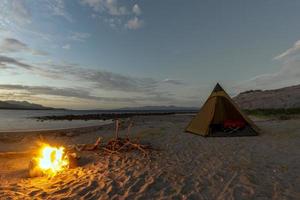 campamento de tiendas en la playa de arena del desierto en california por la noche foto