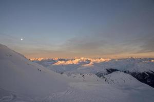 panorama de los alpes suizos de la montaña parsenn en la puesta de sol de invierno foto