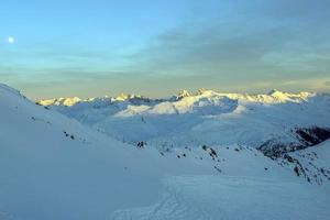 panorama de los alpes suizos de la montaña parsenn en la puesta de sol de invierno foto