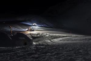 moto de nieve en pista de esquí por la noche foto