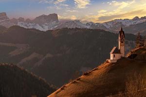 iglesia de montaña dolomitas al atardecer foto