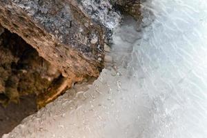 Frozen creek small waterfall in winter time photo