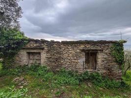 antigua casa de piedra junto a la colina del mar en liguria foto