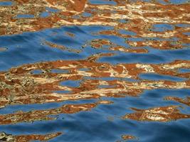 orange reflections on the blue sea like painting photo