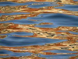 reflejos anaranjados en el mar azul como pintura foto