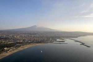 Erupting Etna volcano aerial view at sunrise from airplane photo