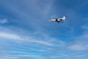 private jet while landing on a blue sky photo