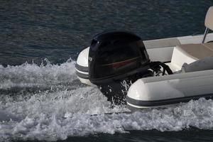 Zodiac outboat motor engine propeller while running on the blue sea photo