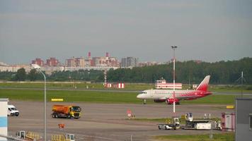 heilige petersburg, Rusland juli 26, 2022 - sukhoi superjet van rossiya taxiën Aan de vliegveld van pulkovo luchthaven. toerisme en reizen concept video