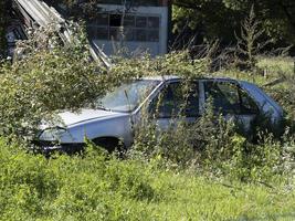 viejo coche oxidado abandonado en un campo foto