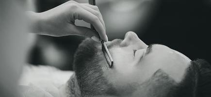 man with a beard on a chair in the barbershop photo