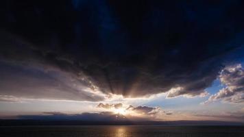 sunset in dark clouds over Dead Sea in winter photo