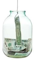 atrapar dólares de ahorro de un frasco de vidrio foto