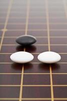 three stones during go game playing photo