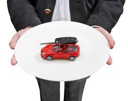 el hombre de negocios tiene un plato blanco con un auto rojo y una llave foto