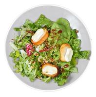 top view of green salad with goat cheese on plate photo