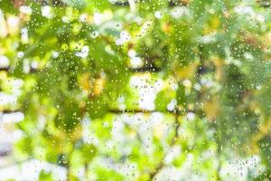 gotas de lluvia en el cristal de la ventana de la casa de campo foto