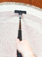 man cleans a carpet with hoover photo