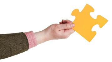 male hand holding big yellow paper puzzle piece photo