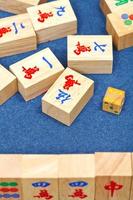 wooden tiles in mahjong game on blue cloth table photo