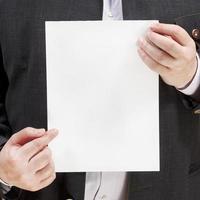 salesman holds blank sheet of paper in hands photo
