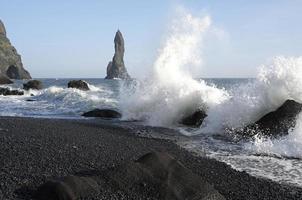 olas que llegan a reynisfjara black beach, islandia, con formaciones rocosas en el fondo foto