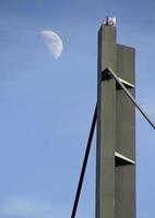 The moon seen next to a bridge in Dusseldorf, Germany photo