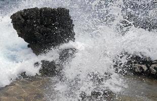 Waves crushing against the shoreline in Capri, Italy photo