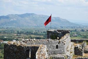 waving the flag of Albania against the blue sky photo