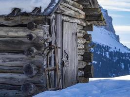 Snow sled outside wooden log cabin hut in winter photo