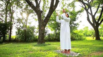 joven musulmán asiático rezando a allah de dios. concepto de festival de ramadán. video