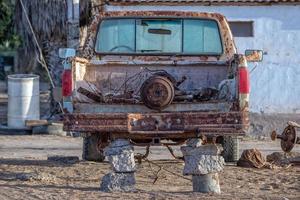 viejo coche abandonado oxidado sin neumáticos foto