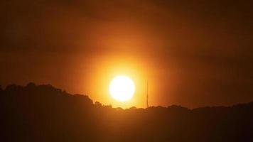 Timelapse av dramatisk solnedgång med orange himmel i en molnig dag. video