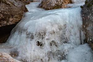 Frozen creek small waterfall in winter time photo