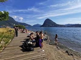 LUGANO, SWITZERLAND - JUNE 23 2019 - Lugano view cityscape from the lake full of people photo