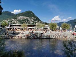 LUGANO, SWITZERLAND - JUNE 23 2019 - Lugano view cityscape from the lake full of people photo