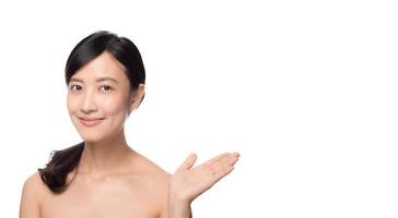 retrato de una hermosa joven asiática limpia el concepto de piel desnuda y fresca. chica asiática belleza cara cuidado de la piel y bienestar de la salud, tratamiento facial, piel perfecta, maquillaje natural sobre fondo blanco foto