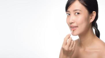 Beautiful portrait young asian woman looking mirror applying makeup lipstick at room. photo