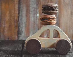 macarons dulces en coche de juguete de madera foto