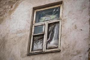 Vieja ventana y pared de madera sucia en el casco antiguo de Europa foto