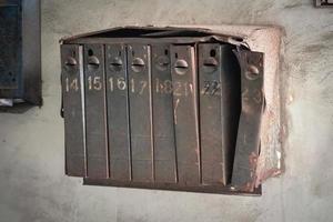 Old mailboxes in the entrance hall white wall of an old weathered residential house photo