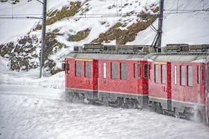 tren rojo en la nieve en los alpes suizos foto