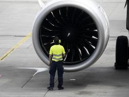 Airport airplane inspector checking engine photo