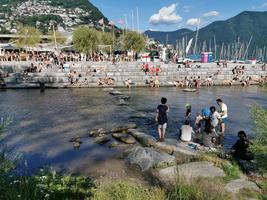 LUGANO, SWITZERLAND - JUNE 23 2019 - Lugano view cityscape from the lake full of people photo