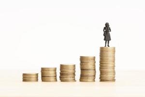 Wealth growth process concept. Woman figurine on Rising Coin stacks. Copy space photo
