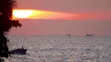 puesta de sol sobre el paisaje oceánico con jetski, playa karon, phuket, tailandia video