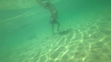 Young couple swimming at tropical sea, underwater view video