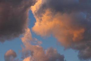 Cloud landscape. Pink and brown summer cumulus clouds on a blue sky during sunset. Wallpaper. Background. photo