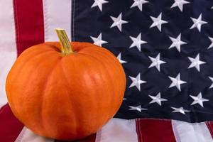 Thanksgiving Day. Orange pumpkin on the background of the flag of America. photo